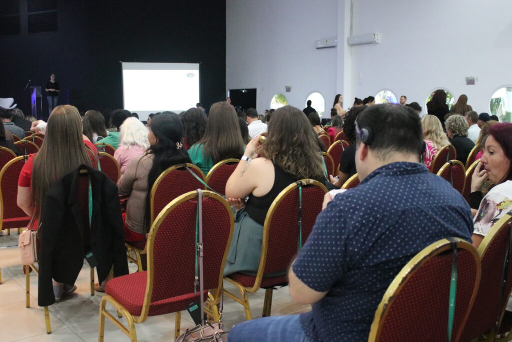 Montagem de duas fotografias que mostra a audiodescritora Ana Paula Possapp em narração de Audiodescrição simultânea durante um evento corporativo.