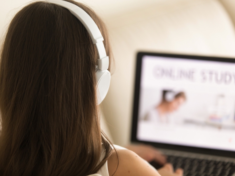 Acessibilidade Digital - Mulher com fone de ouvido estudando em um laptop.